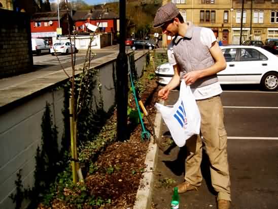 A Volunteer planting seeds in a parking lot garden in Todmorden, England. Photo Courtesy: Incredible Edible